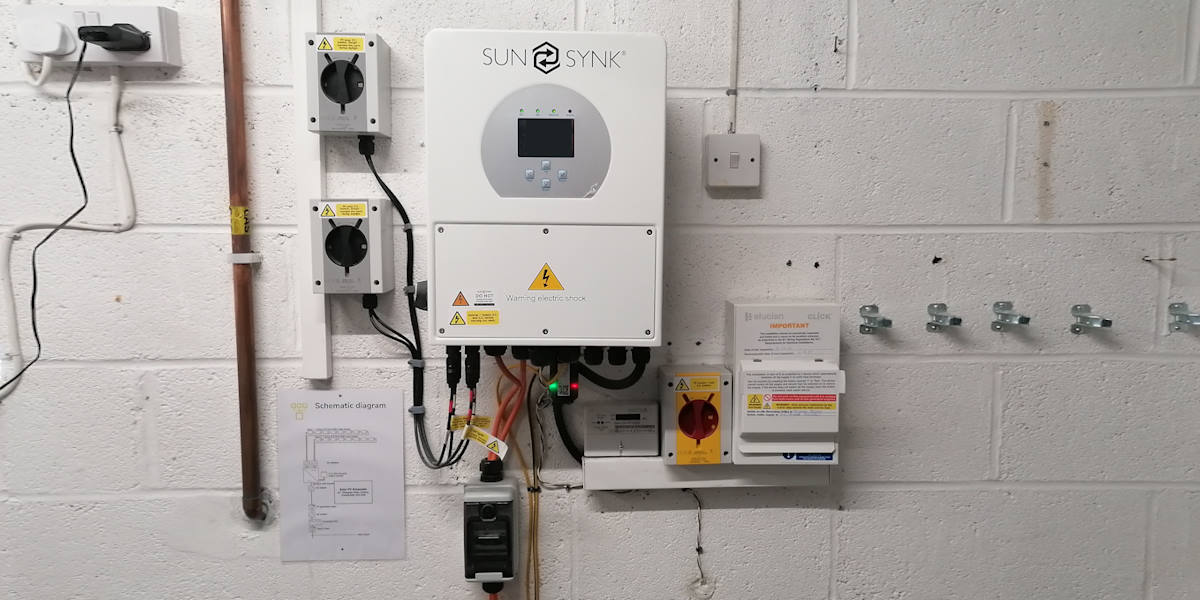 Solar PV installation components including inverter, switches and fuse box.